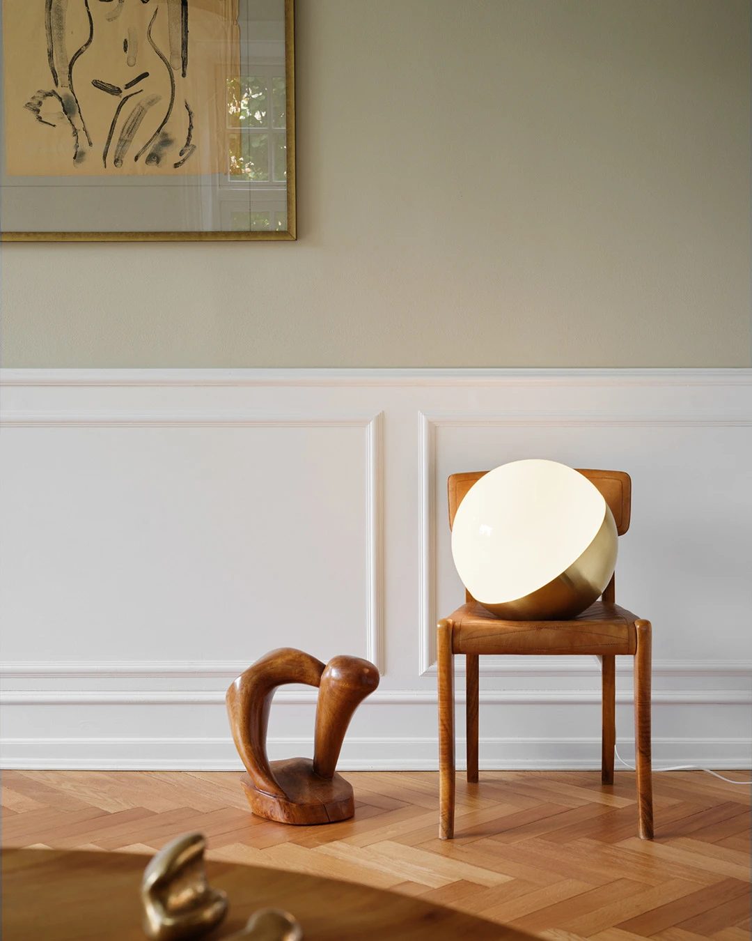 VL Studio Table/Floor lamp in Opal White on wooden chair in living room, © 2025 Louis Poulsen.