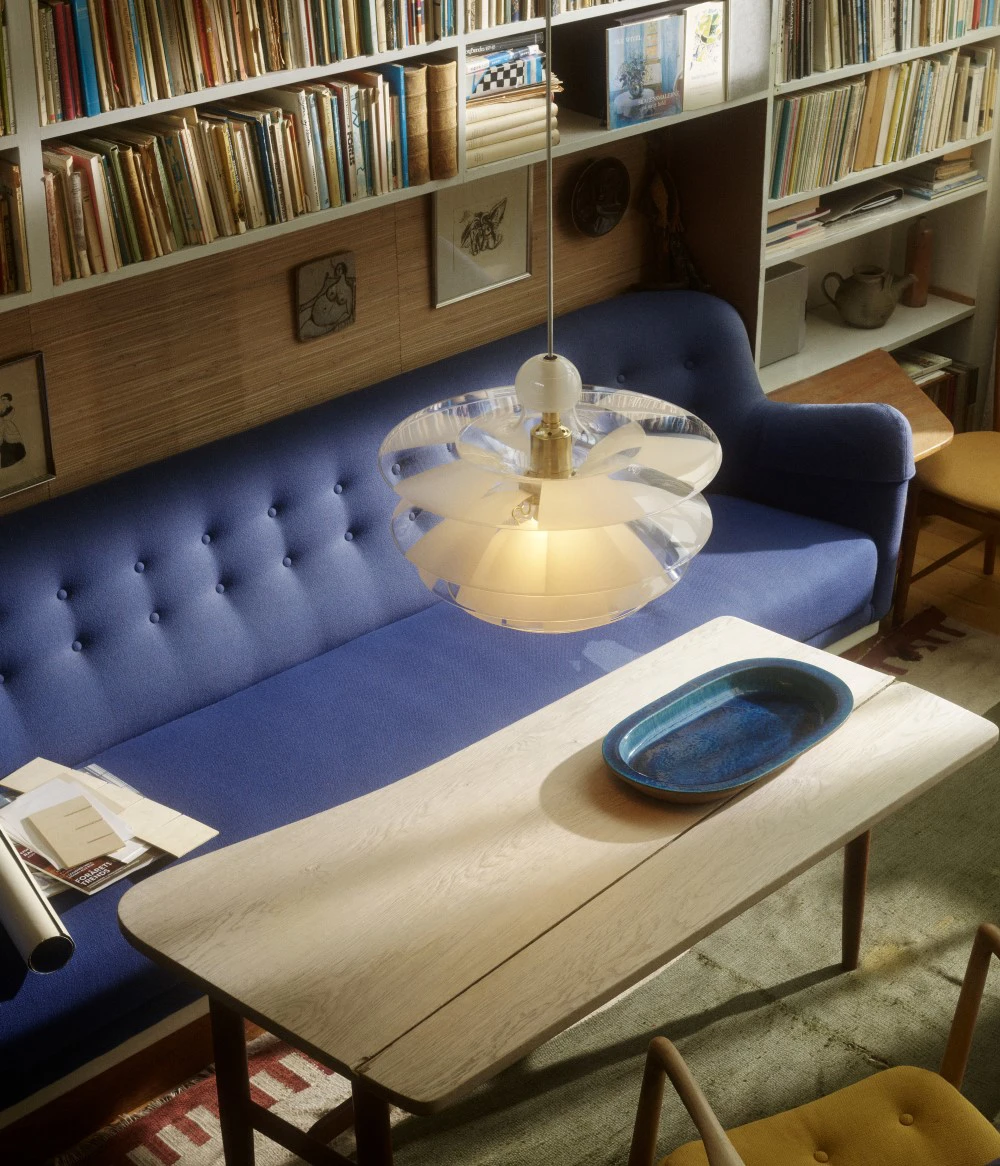 PH Septima in glass and Brass above wooden table in living room, © 2025 Louis Poulsen.