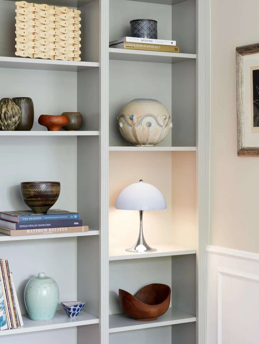 Panthella 250 Portable in Opal Blue on shelf in living room, © 2025 Louis Poulsen.