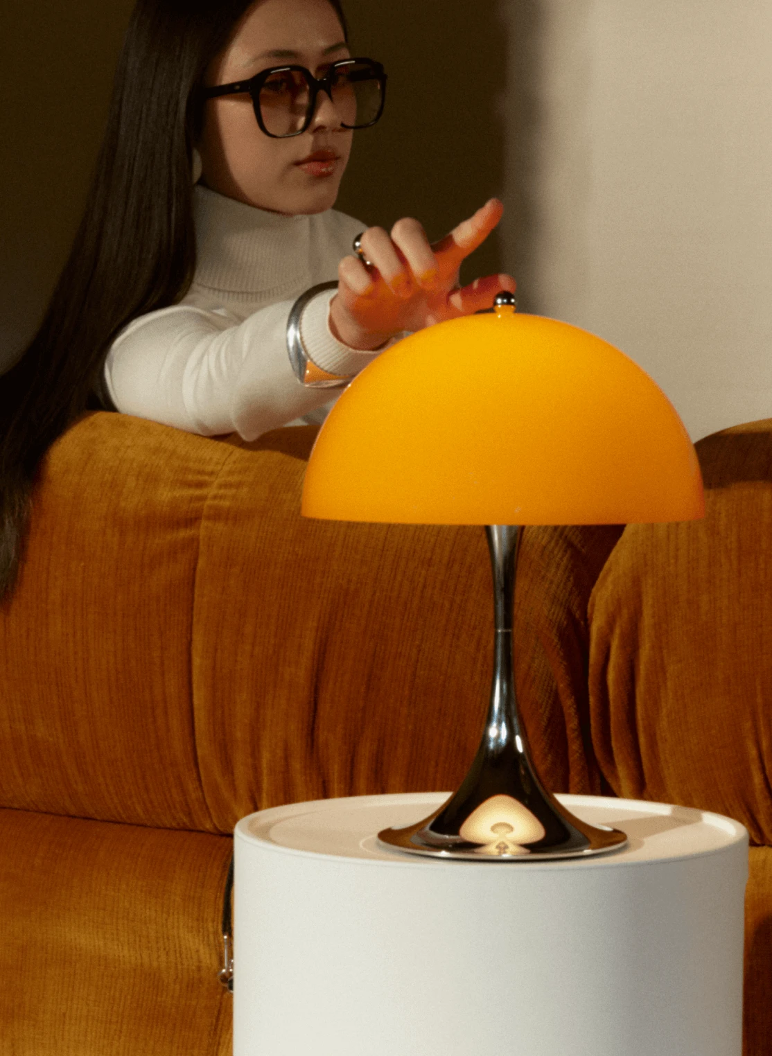 Chrome と opal orange の Panthella 250 Portable がラウンジテーブルに配置, © 2025 Louis Poulsen.
