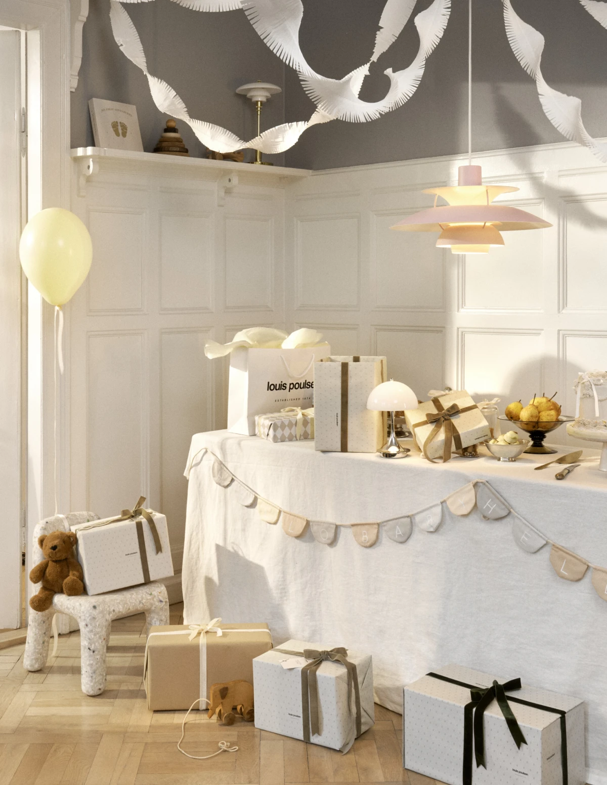 Panthella Portable and PH lamps on a party table with gifts and decorations, © 2025 Louis Poulsen.