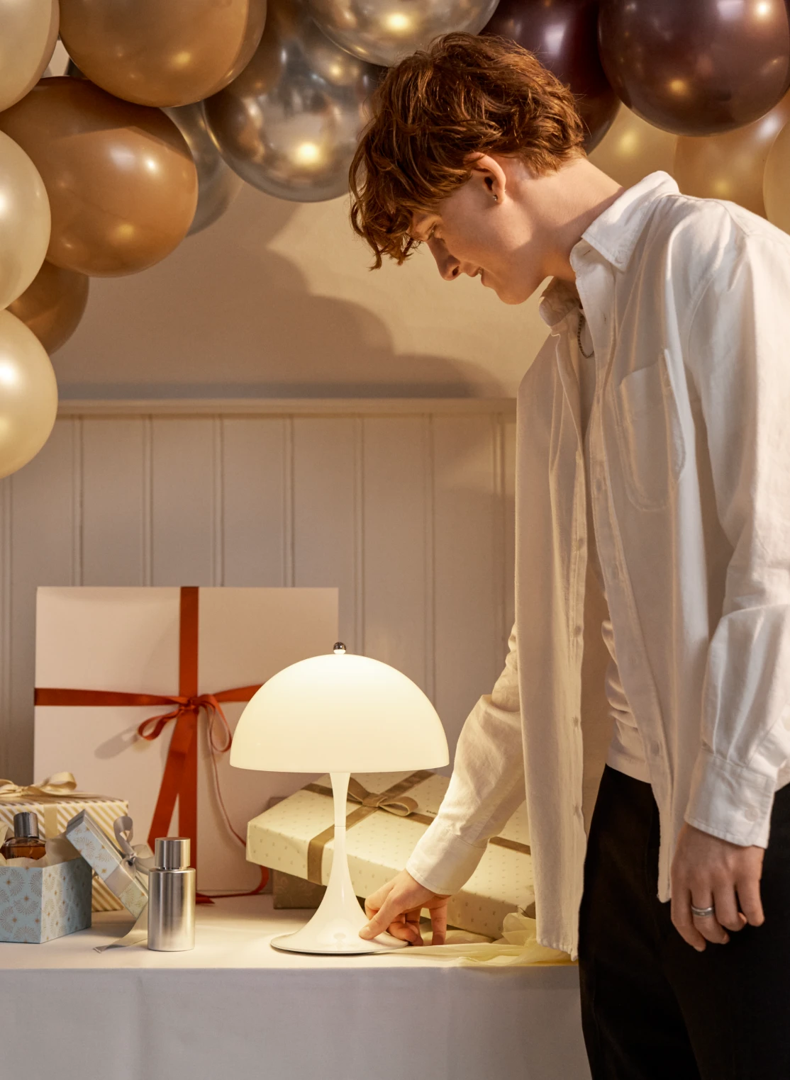 Panthella 250 Portable in White Classic on gift-covered table setting, © 2025 Louis Poulsen.