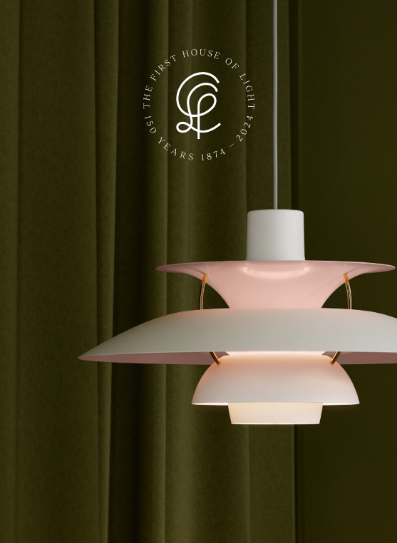 A PH 5 Anniversary Edition pendant in soft pink and white against dark green curtains. © 2026 Louis Poulsen.