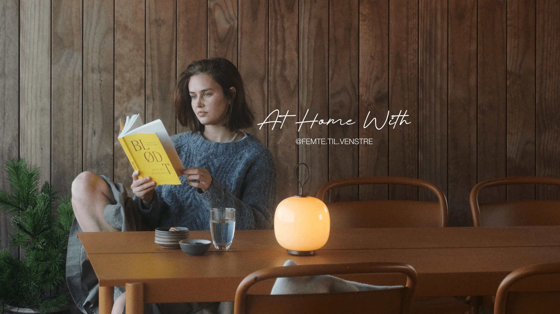 VL45 Portable lamp on dining table beside woman reading book, © 2025 Louis Poulsen.