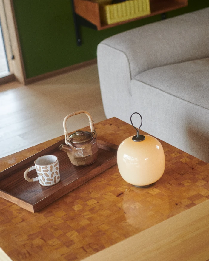 VL45 Portable lamp on coffee table beside teapot and cup, © 2025 Louis Poulsen.