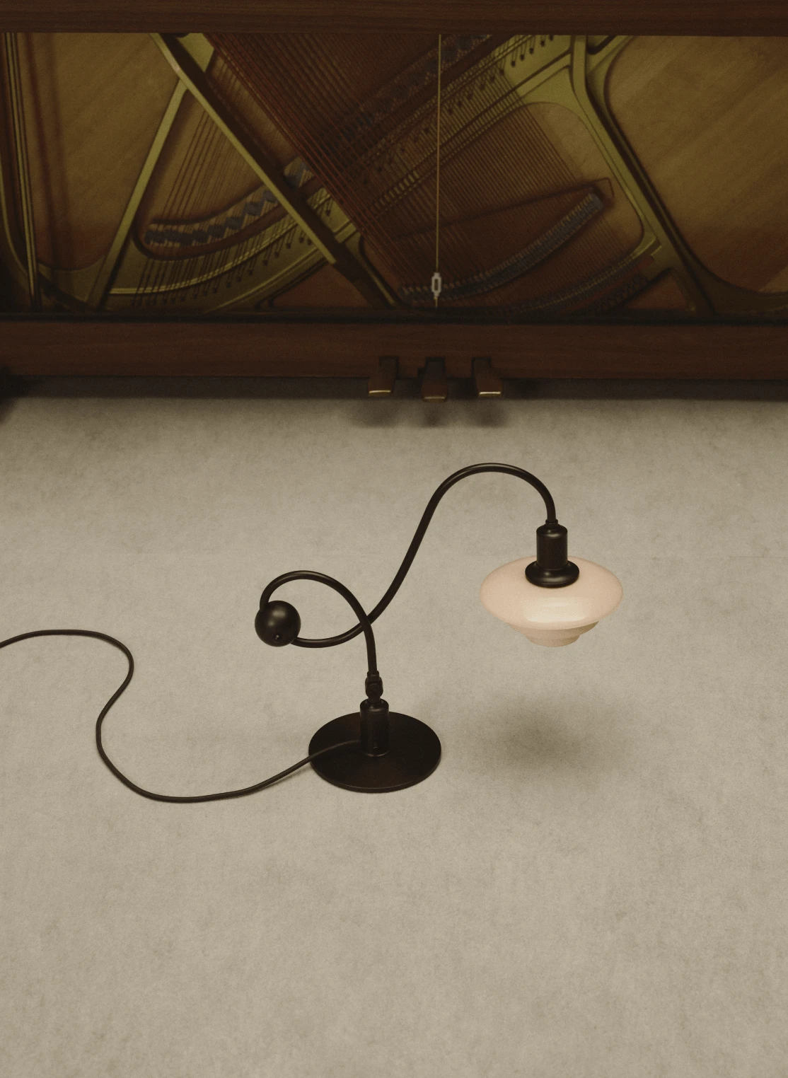 PH 1/1 Piano Lamp이 열린 피아노 아래에 놓인 모습, © 2025 Louis Poulsen.