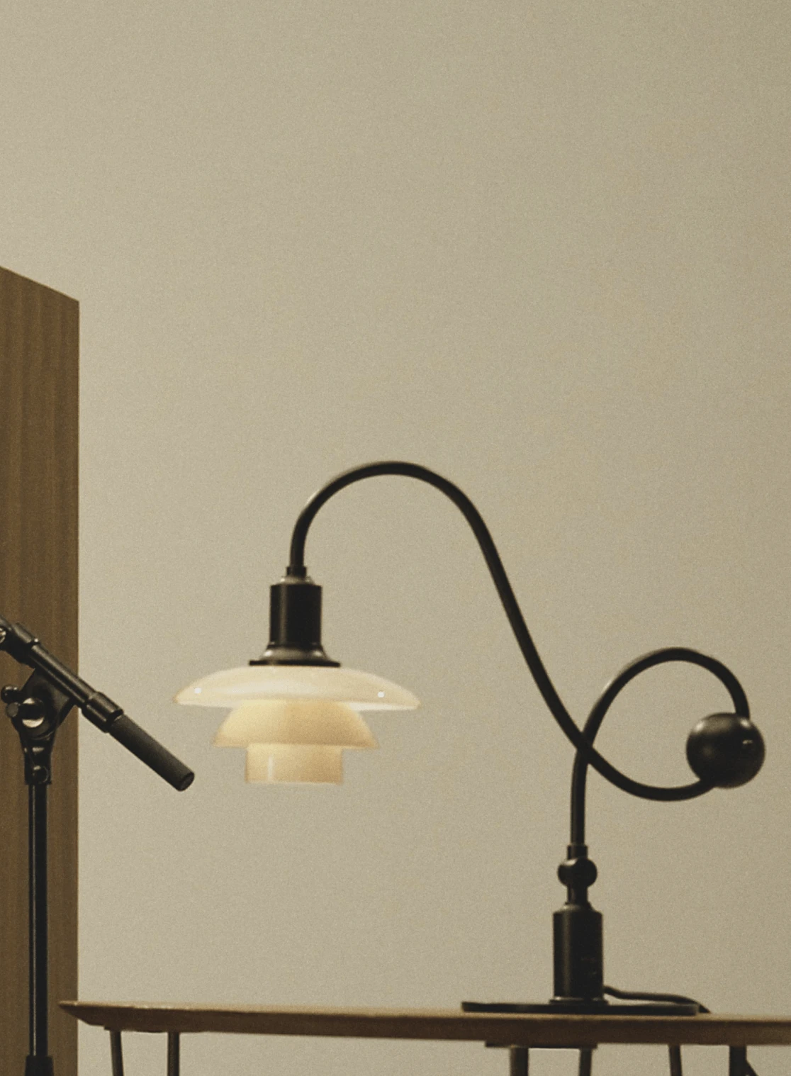 켜진 PH 1/1 Piano Lamp이 녹음 장비 옆에 놓인 모습, © 2025 Louis Poulsen.