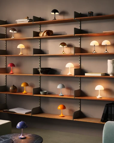 Panthella 160 Portable Lamps in a range of colours sit on shelves and a marble table in a warmly lit room. © 2026 Louis Poulsen.