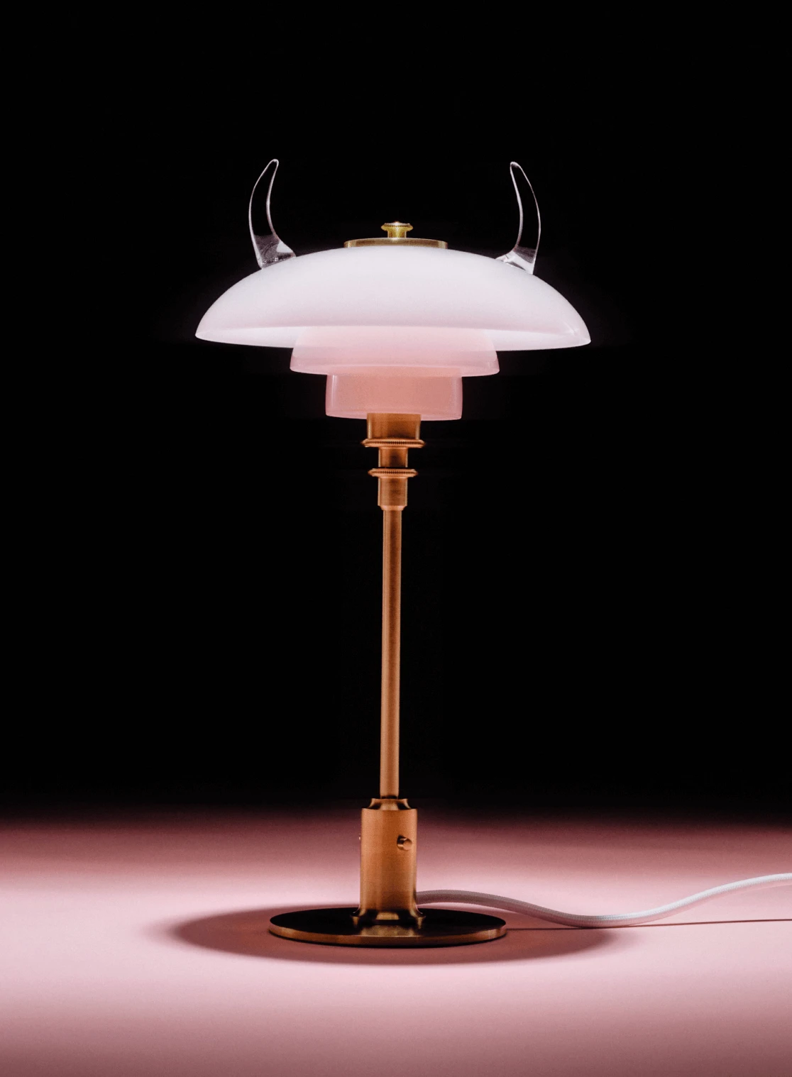 PH 2/2 Question Mark Pale Rose Table Lamp with an opal glass shade and curved arms against a black background. © 2026 Louis Poulsen.