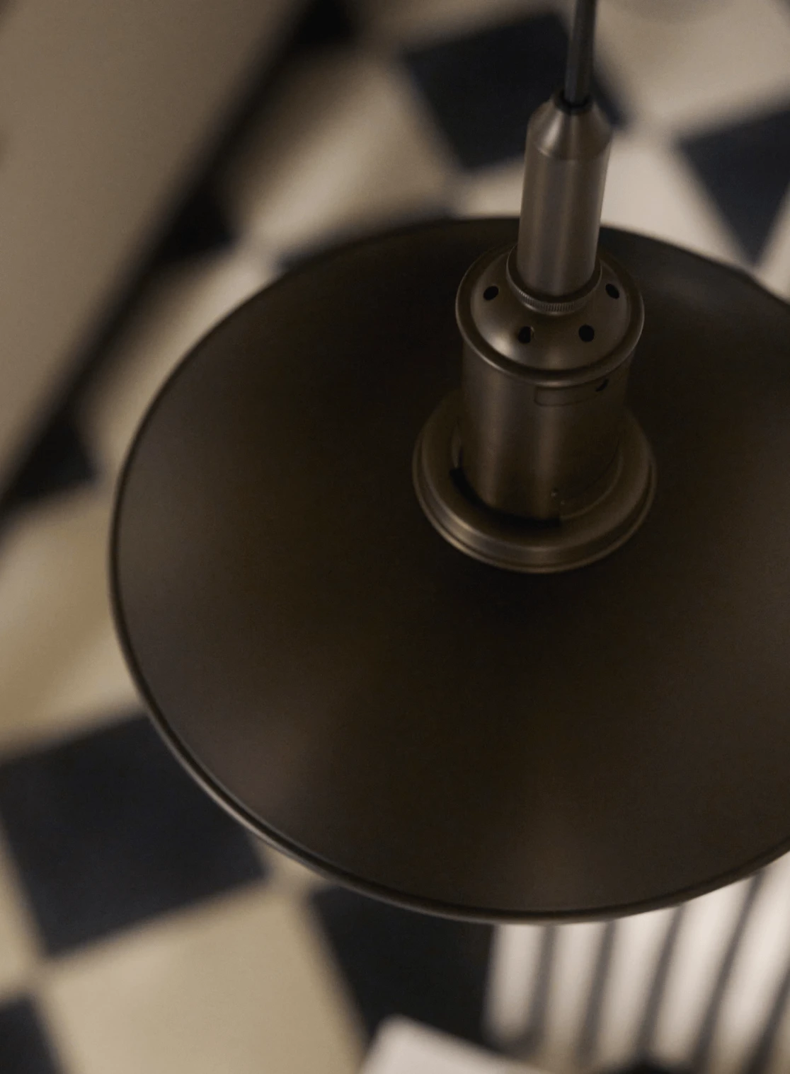 PH Aged Brass pendant lamp in modern interior with geometric flooring, © 2025 Louis Poulsen.