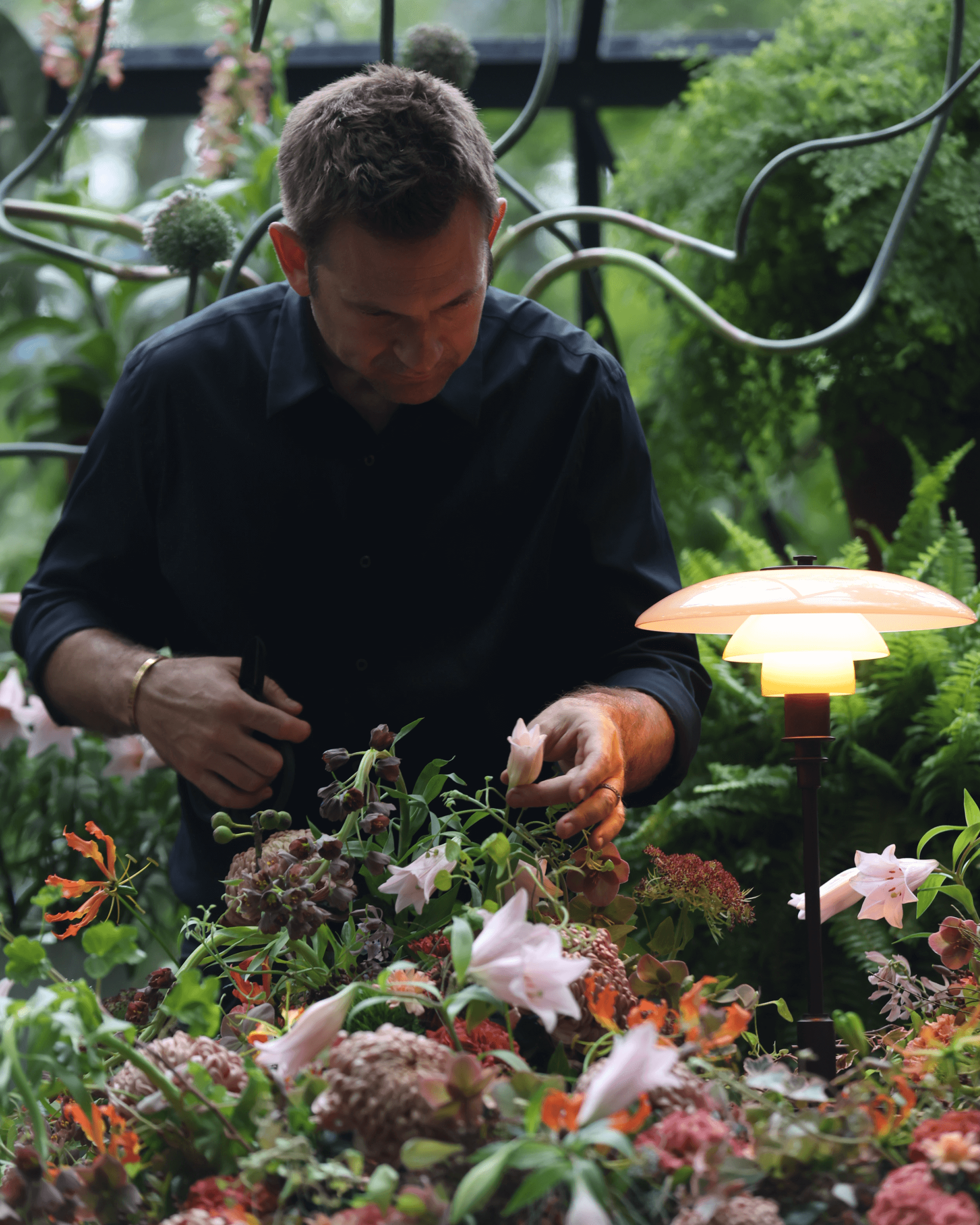 PH 3/2 Limited Edition Table Lamp illuminating flowers as Nicolai Bergmann arranges bouquet, © 2025 Louis Poulsen.