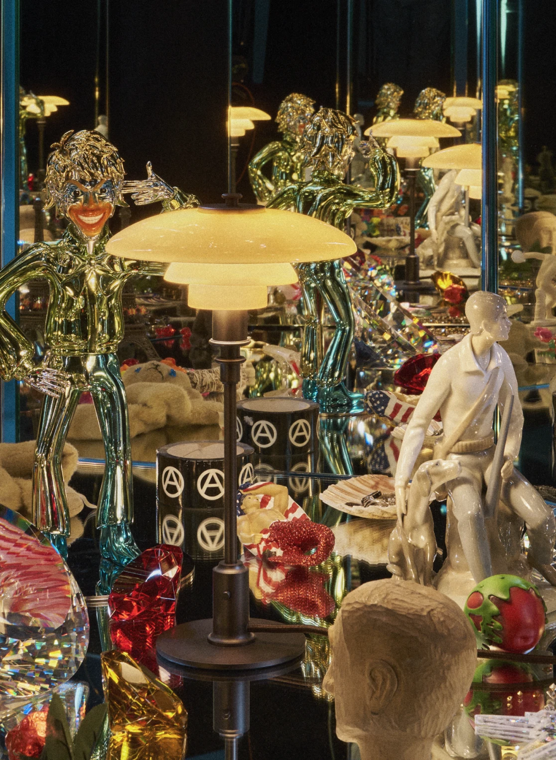 A PH 2/1 Table Lamp with pale shades and a dark base among sculptures and colourful objects in a mirrored room. © 2026 Louis Poulsen.