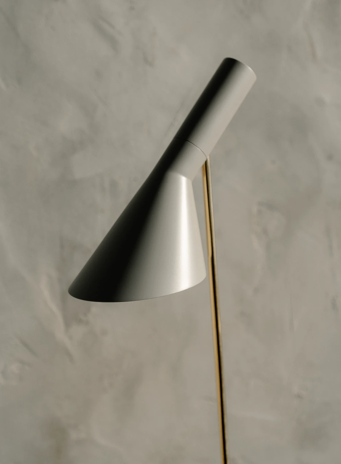 Detail of AJ Floor lamp with brass stem and matte grey shade, © 2025 Louis Poulsen.