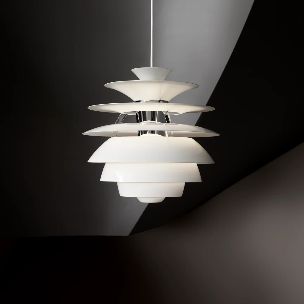 A white PH Snowball pendant glows against a dark, angular background. © 2026 Louis Poulsen.