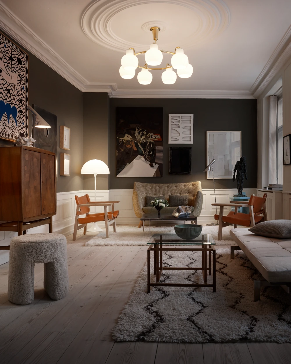 A PH 1/1 Chandelier Centenary Edition lights a living room with a Panthella Floor Lamp beside an armchair. © 2026 Louis Poulsen.