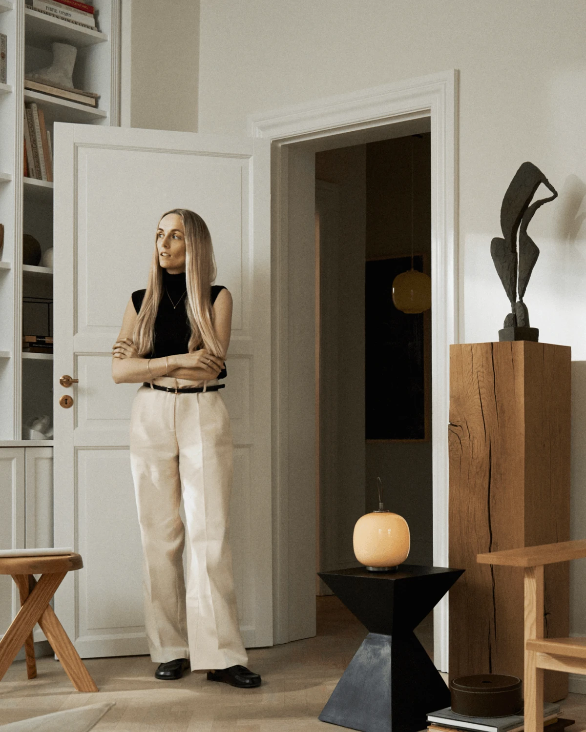 A VL 45 Radiohus Portable Lamp casts a warm amber glow from a black side table in a home. © 2026 Louis Poulsen.