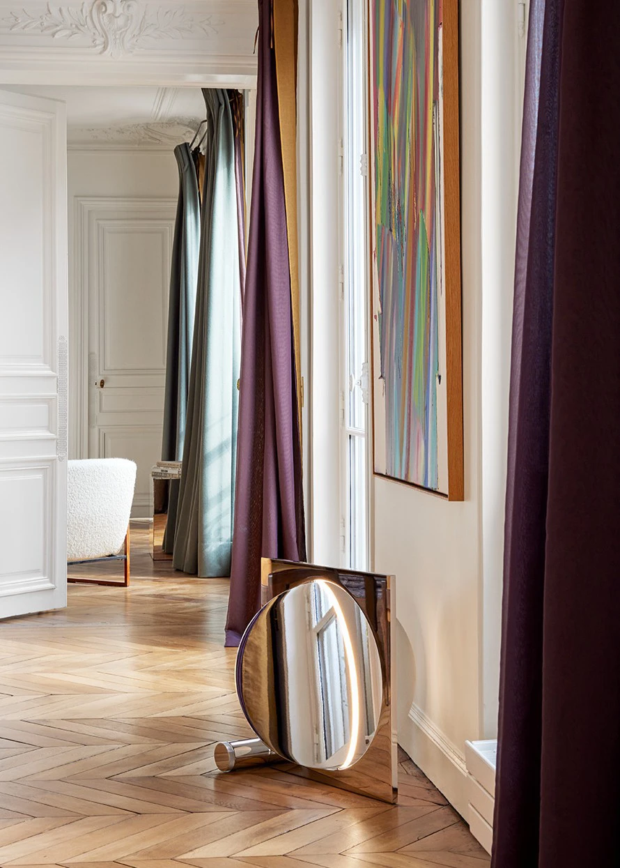 Moonsetter floor lamp in a bright hallway with herringbone parquet, long curtains and ornate wall mouldings. © 2026 Louis Poulsen.