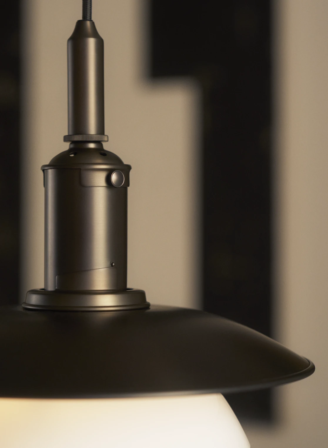 Close-up of the PH 3/3 pendant light in aged brass, showing intricate detailing on the fixture, © 2025 Louis Poulsen.