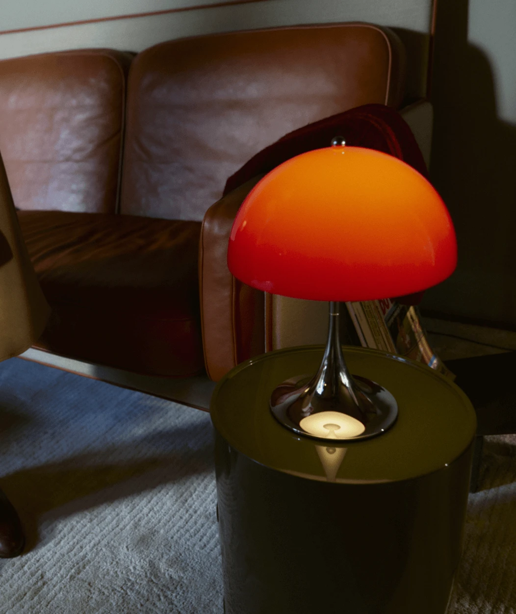 Panthella 250 Portable in Red op een bijzettafel in warm interieur, © 2025 Louis Poulsen.