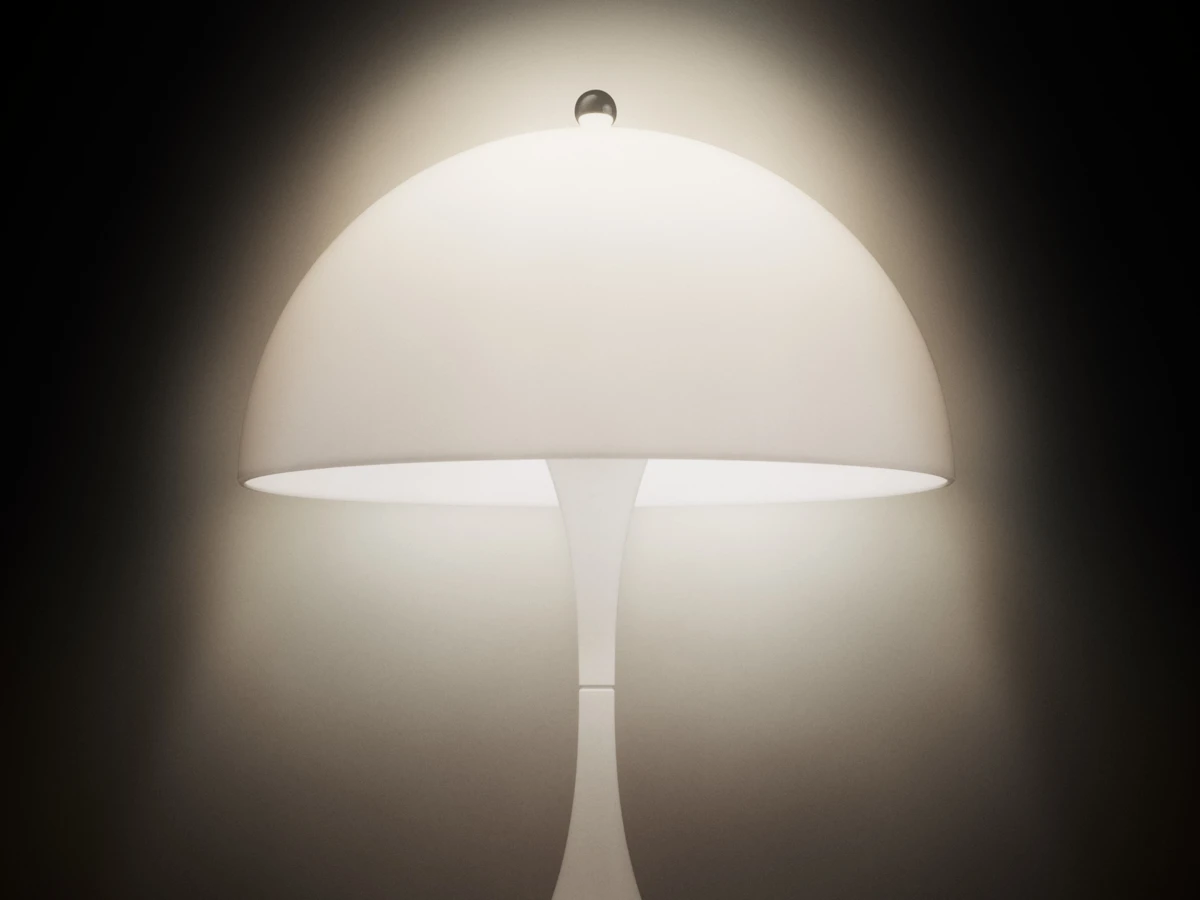 De Panthella 160 Portable Lamp met witte opalen kap brandt tegen een donkere, neutrale achtergrond. © 2026 Louis Poulsen.
