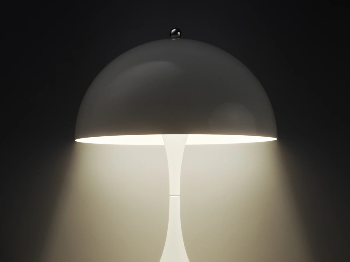 De witte Panthella 160 draagbare lamp brandt onder de koepelvormige kap tegen een donkere achtergrond. © 2026 Louis Poulsen.