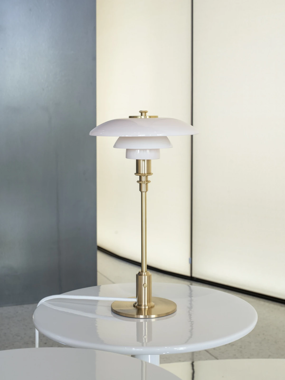 PH 2/1 table lamp with a soft yellow backdrop, © 2025 Louis Poulsen.
