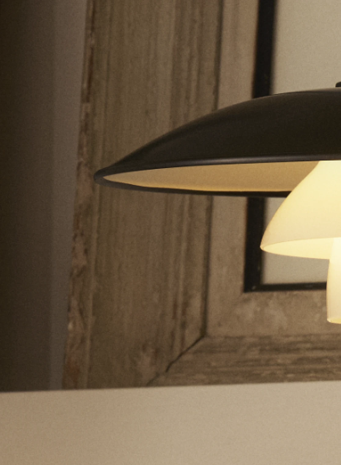 PH 3/2 Aged Brass table lamp with a sleek metal finish, set against a neutral-toned background, © 2025 Louis Poulsen.
