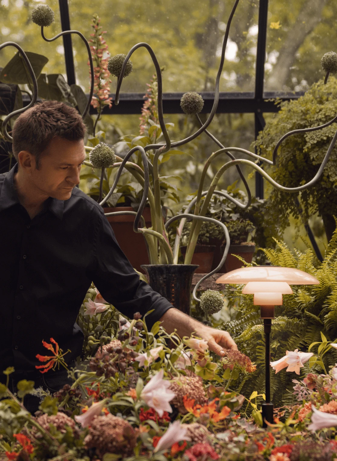 PH 3/2 Limited Edition lamp with Nikolaj Bergman in floral setting, © 2025 Louis Poulsen.