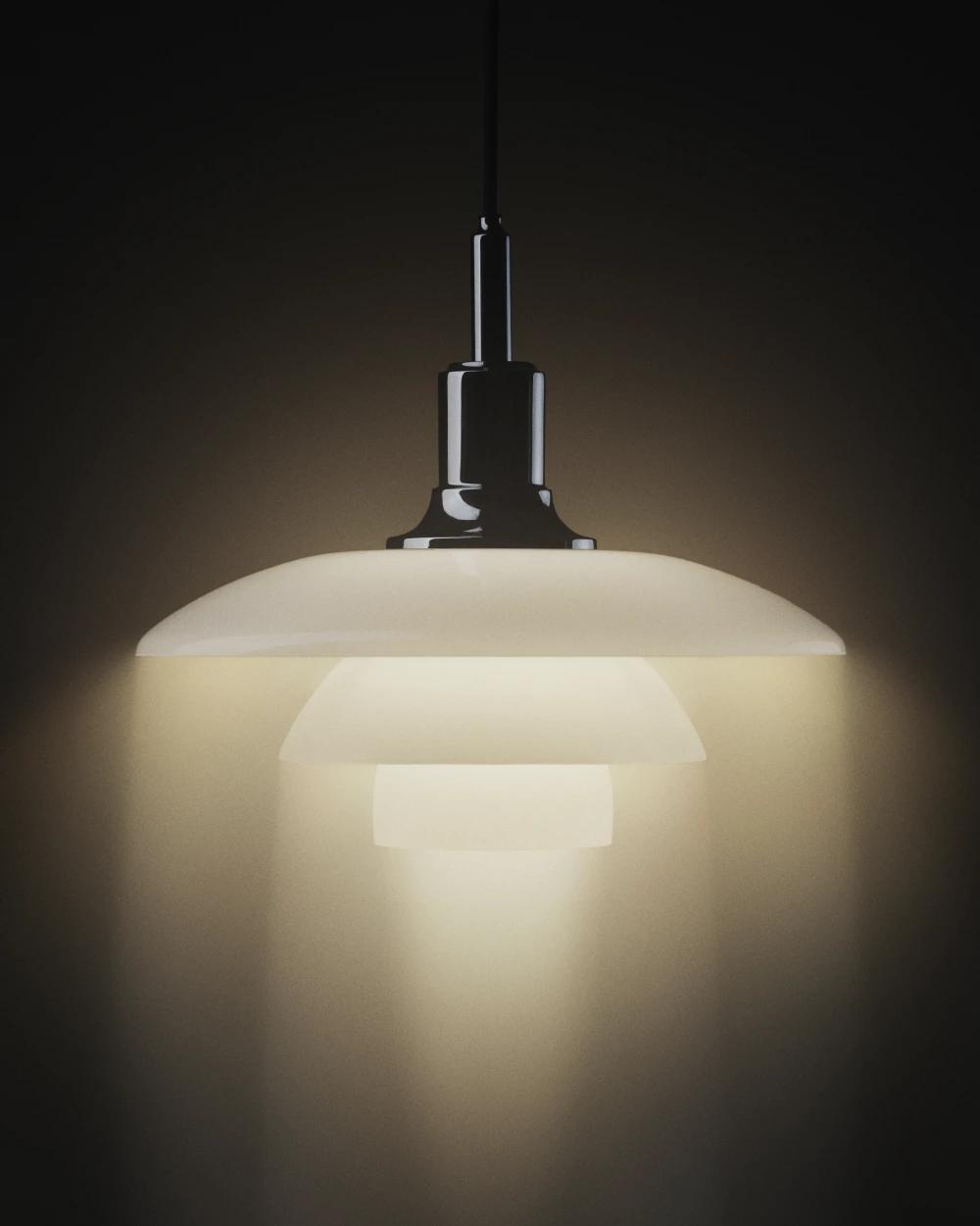 A white PH 5 pendant casts a warm glow against a dark background. © 2026 Louis Poulsen.