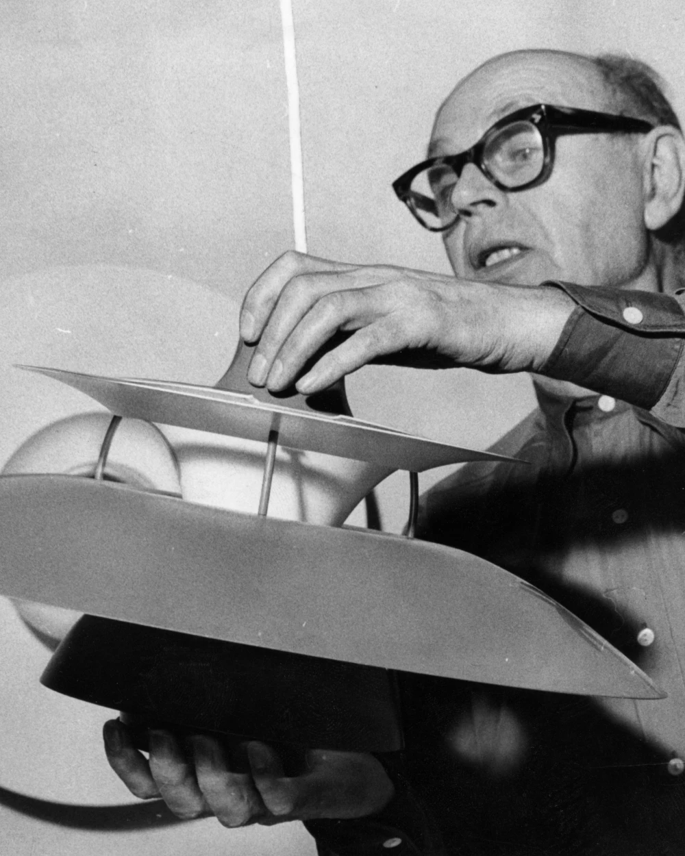 Poul Henningsen ajuste une lampe PH à plusieurs abat-jours, © 2025 Louis Poulsen.