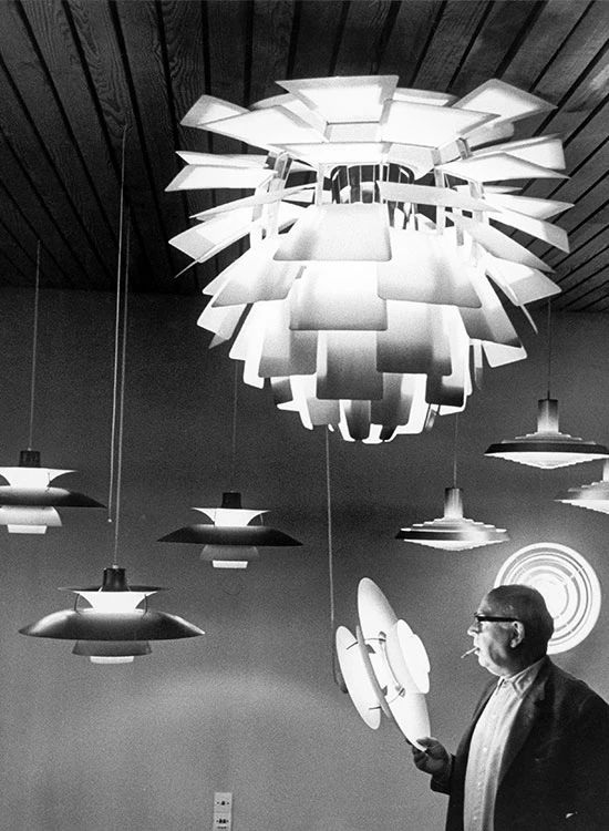 Poul Henningsen bekijkt Artichoke en PH lampen in showroom, © 2025 Louis Poulsen.
