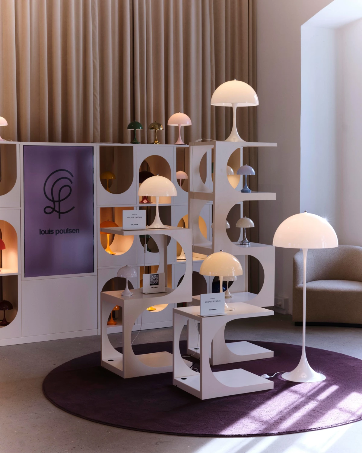 Een witte Panthella Floor Lamp staat tussen tafellampen in de Louis Poulsen-showroom in Kopenhagen. © 2026 Louis Poulsen.