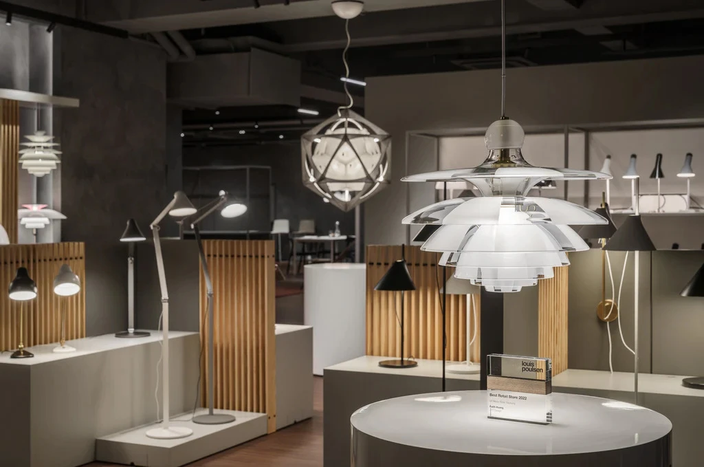 白いPH Artichokeのペンダントライトが、Louis Poulsenの照明器具が並ぶ台中店に吊り下げられている。 © 2026 Louis Poulsen.