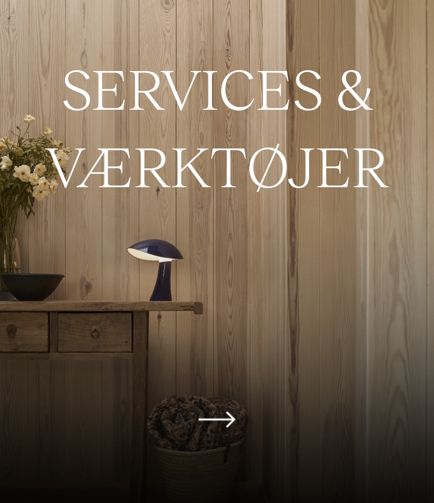 Services & værktøjer – en mørkeblå Panthella 160 Portable Lamp står på en trækommode. © 2026 Louis Poulsen.