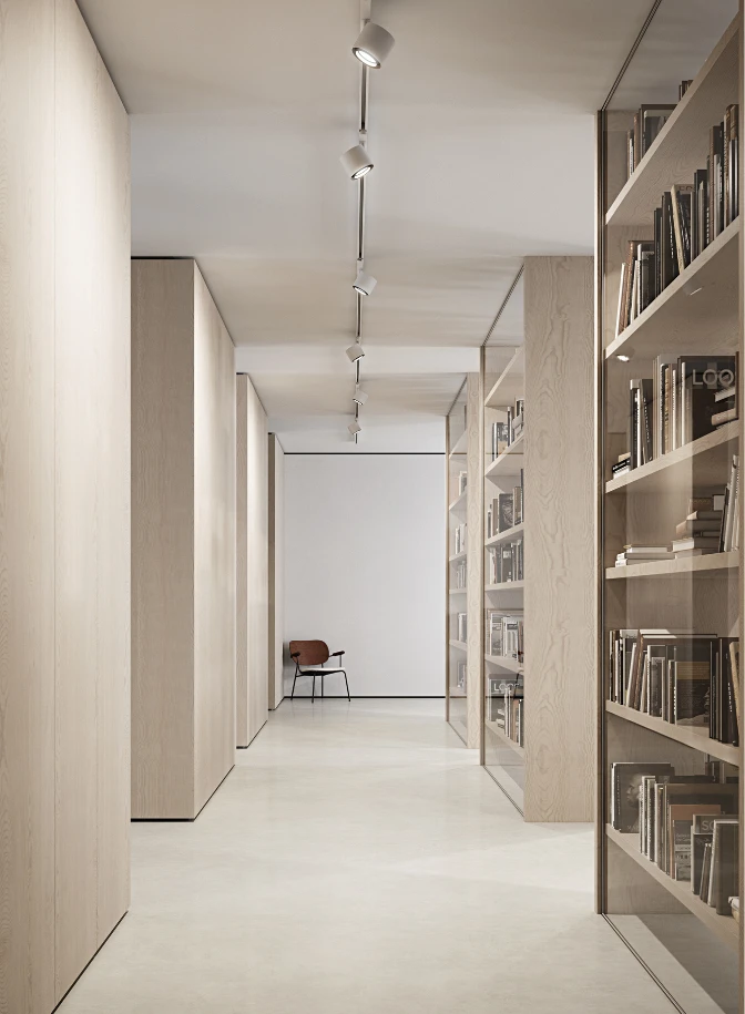 LP Xperi track lights illuminate a quiet corridor lined with pale wood bookshelves and books. © 2026 Louis Poulsen.