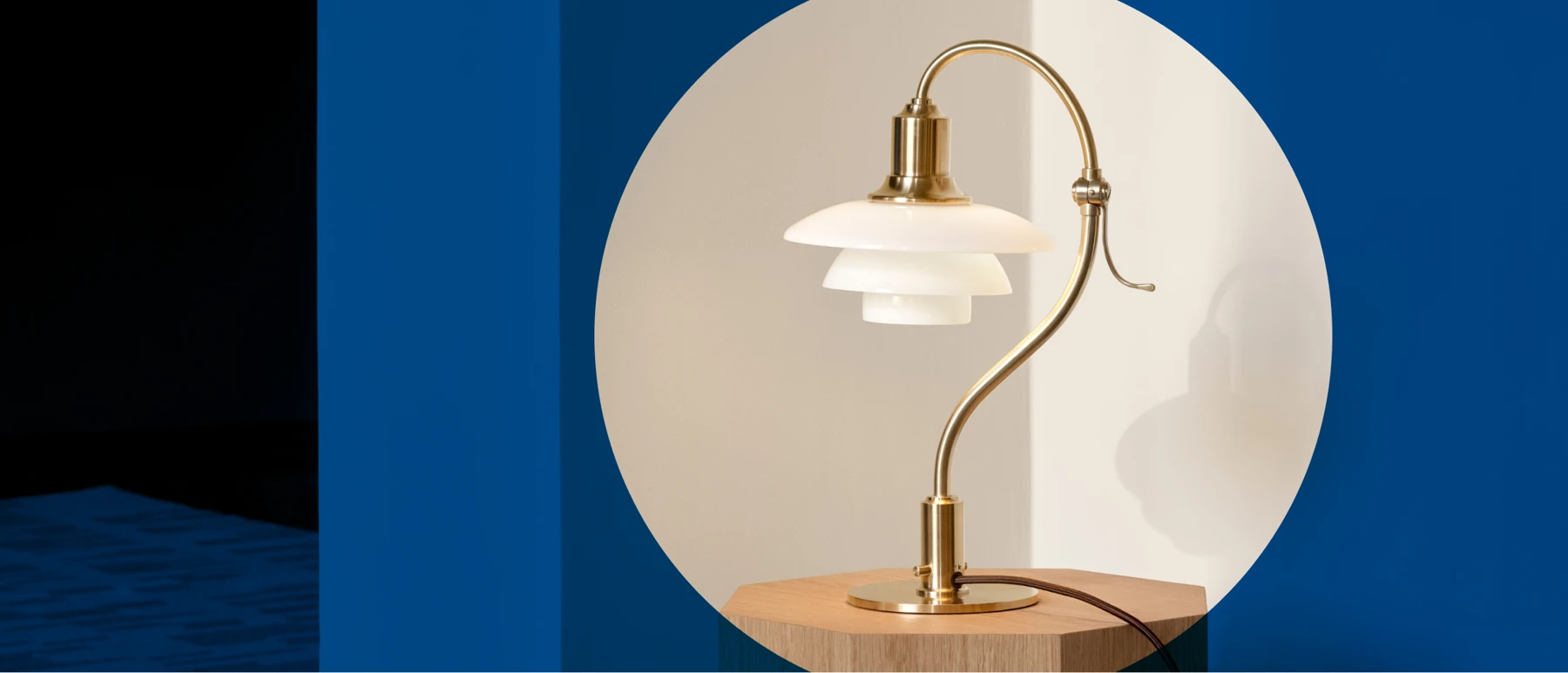 PH 2/2 Question Mark Table Lamp in a Pale Rose finish, with white glass shades on a wooden table. © 2026 Louis Poulsen.