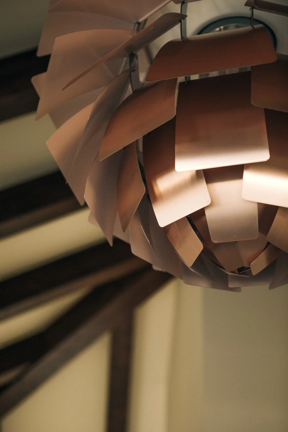 Close-up of a PH Artichoke Pale Rose pendant, its layered shades glowing warmly. © 2026 Louis Poulsen.