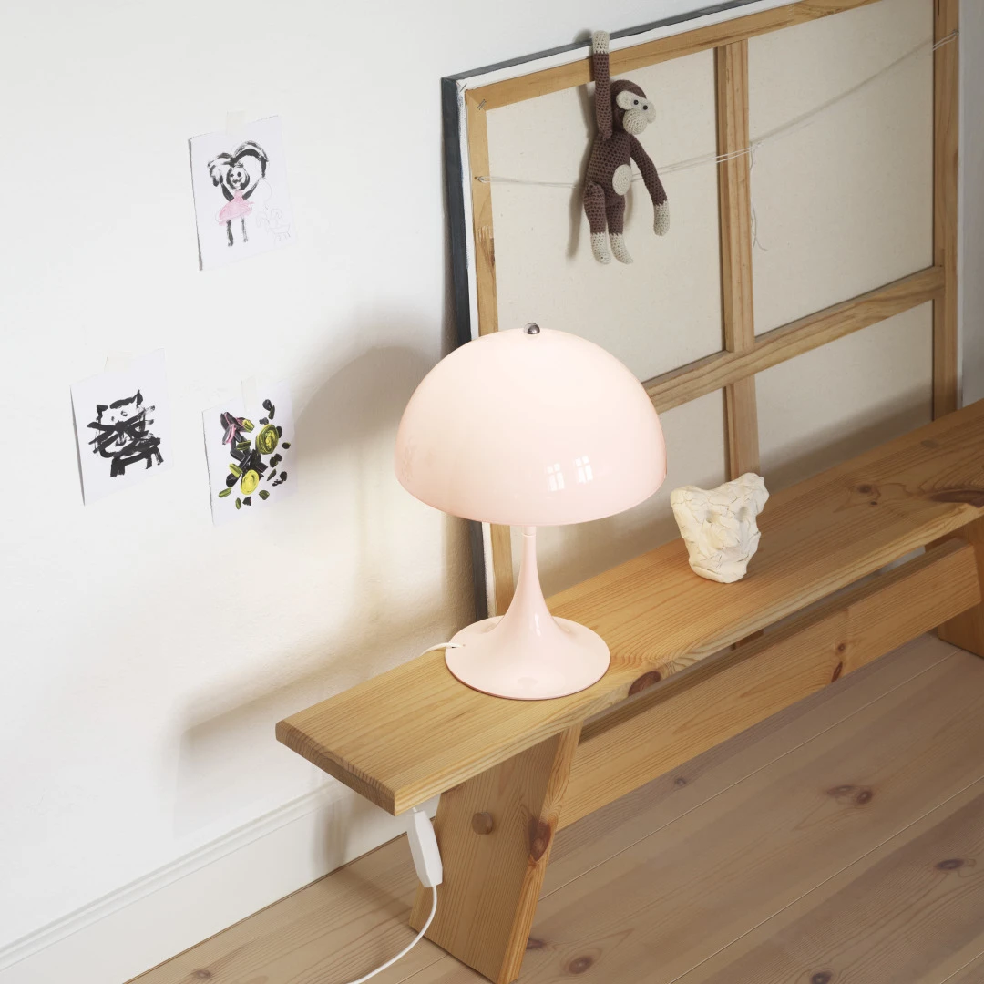 A pale pink Panthella 250 Table Lamp sits on a pine bench beneath children's drawings on the wall. © 2026 Louis Poulsen.