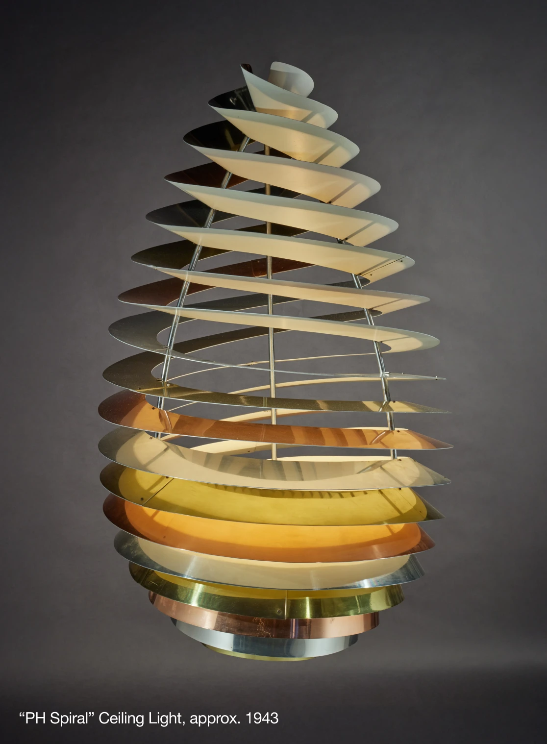A sculptural Louis Poulsen ceiling light with spiralling metal shades; the image labels it “PH Spiral,” circa 1943. © 2026 Louis Poulsen.