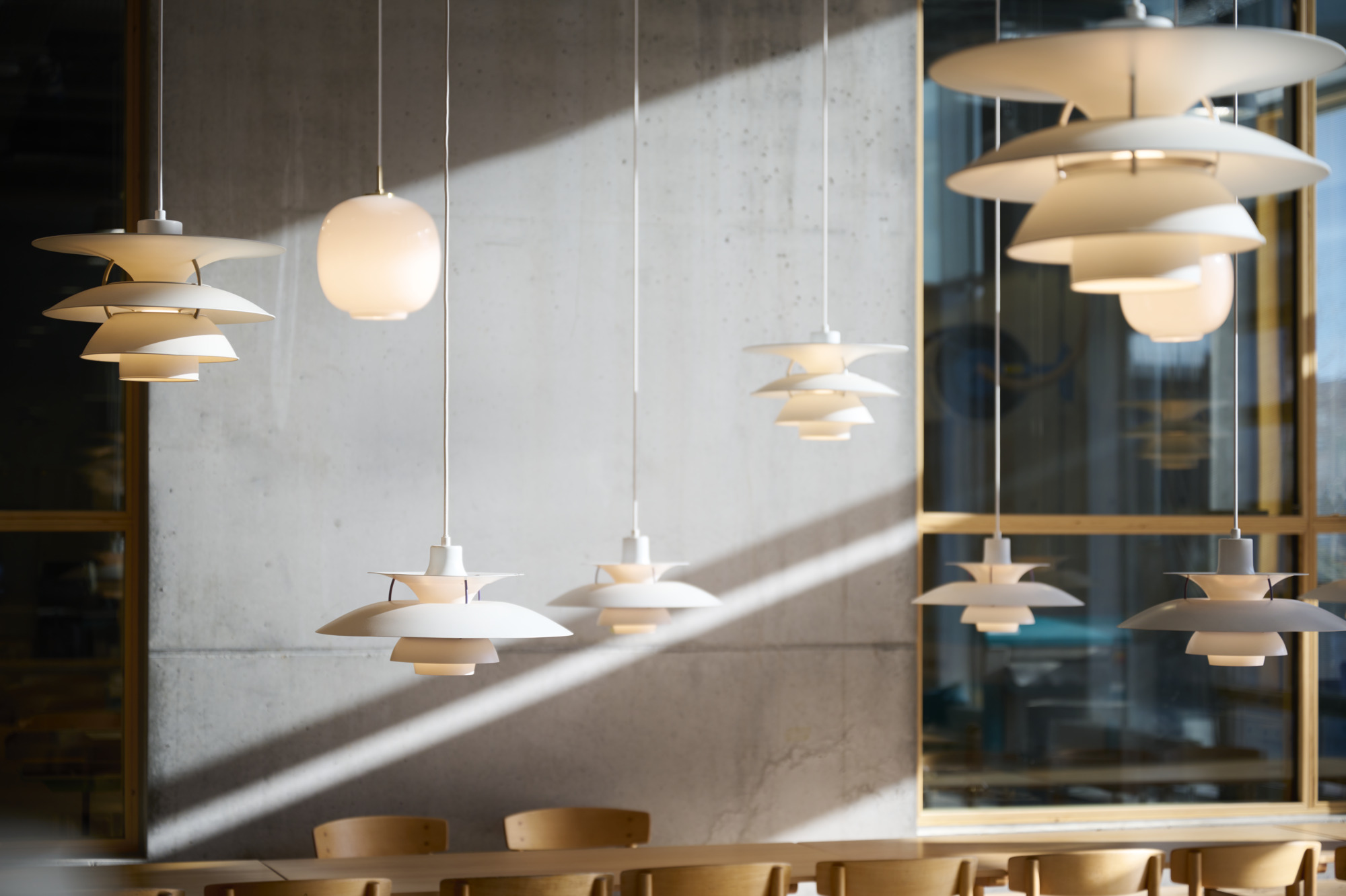 White PH 5 pendants and PH 5-4½ & PH 6½-6 pendants hang above tables at Aarhus School of Architecture. © 2026 Louis Poulsen.