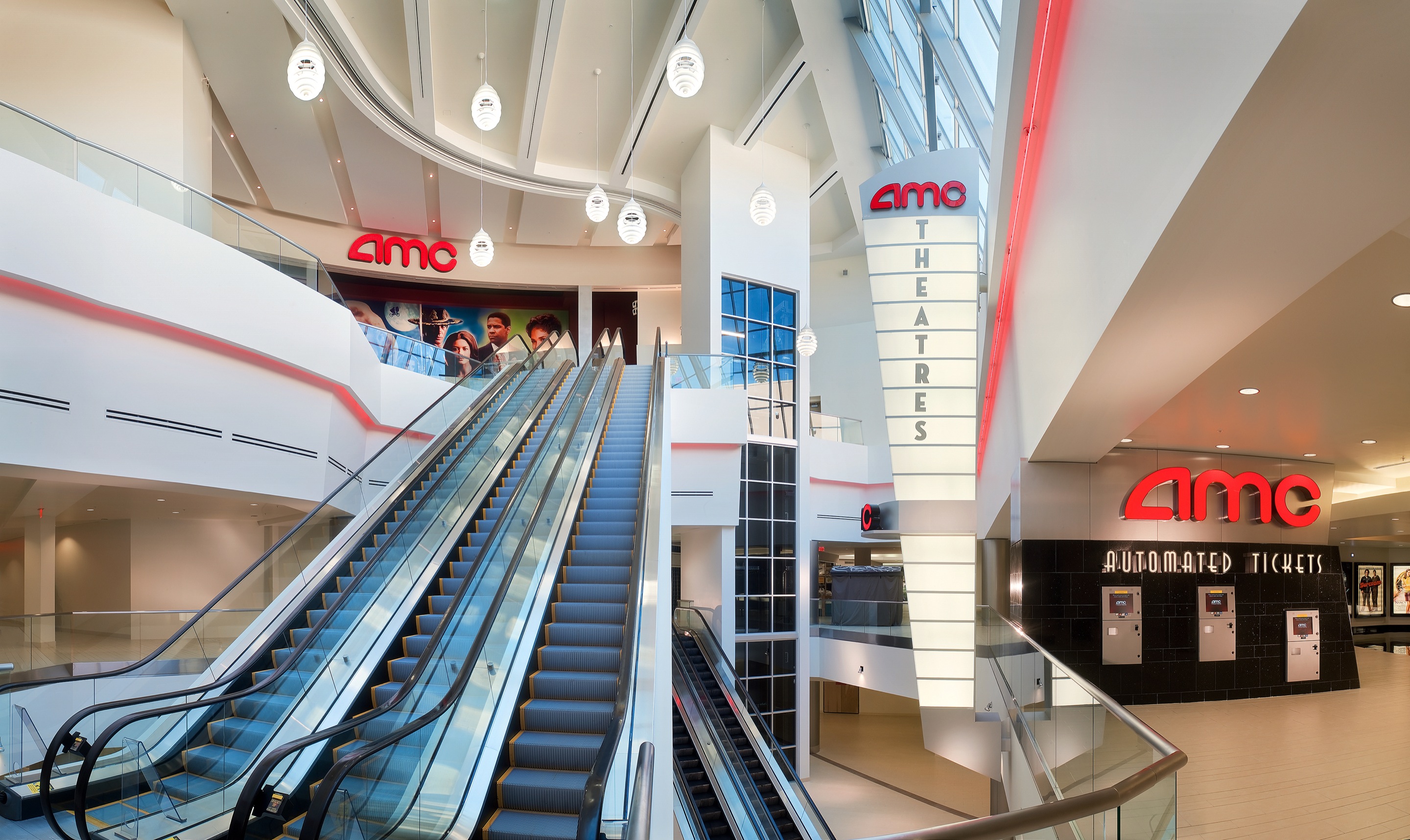 Louis Poulsen pendants hang above the escalators in the AMC cinema at Vallco Mall in Cupertino. © 2026 Louis Poulsen.