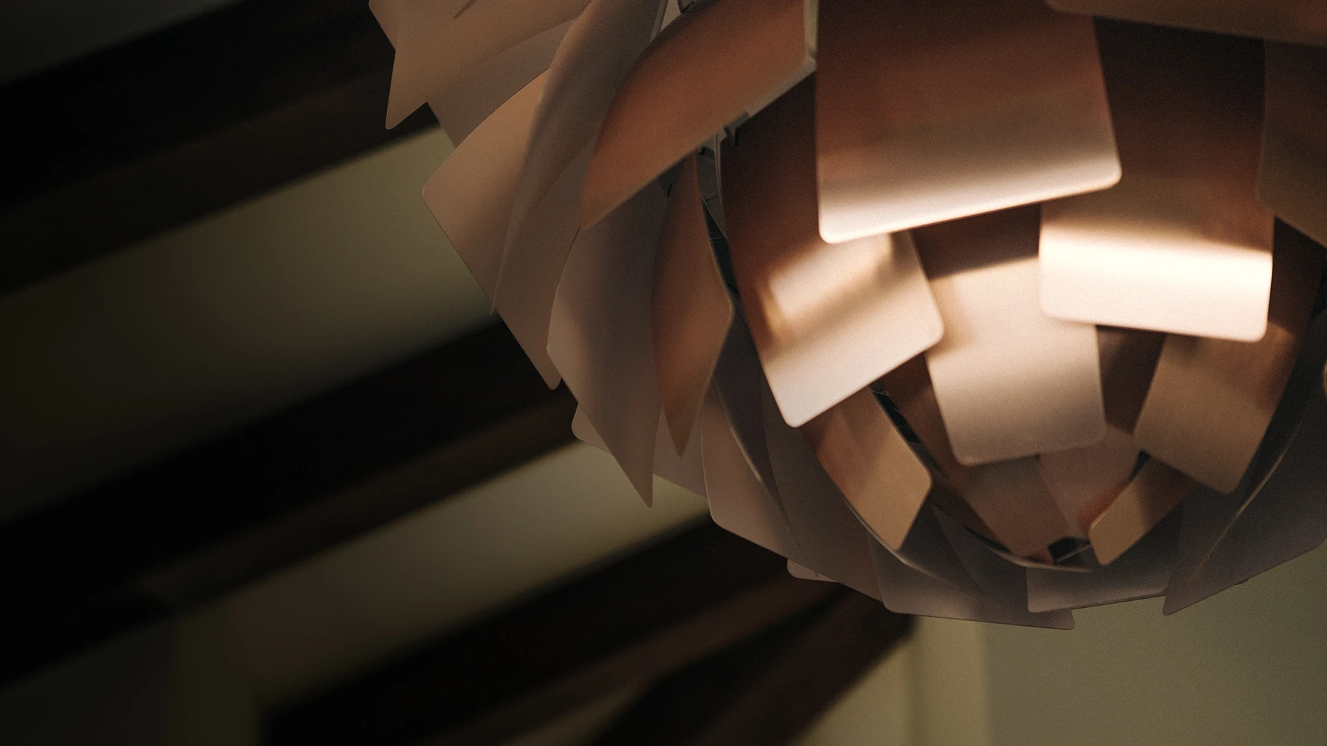 A PH Artichoke pendant glows warmly, its layered leaves filling the frame against a dark background. © 2026 Louis Poulsen.